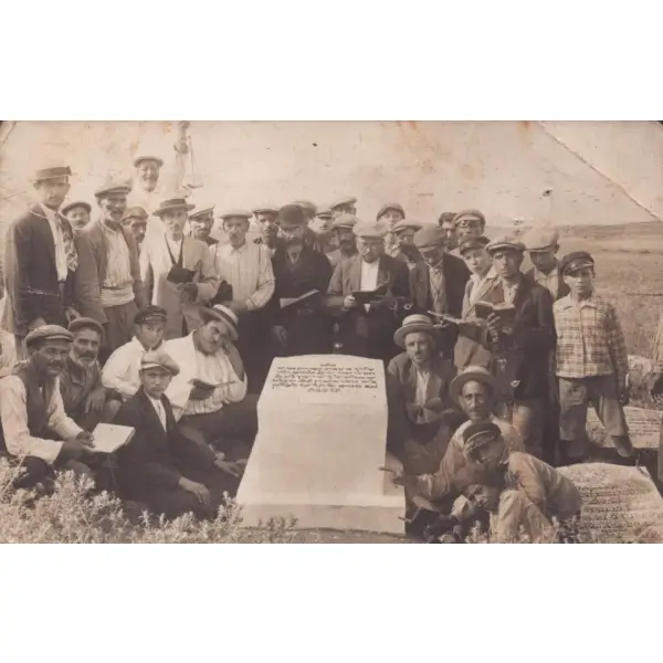 İbranice mezar taşı başında poz veren, her biri şapkalı ve ellerinde dua kitapları olan bir topluluk, arkası İbranice yazılı, 9x14 cm