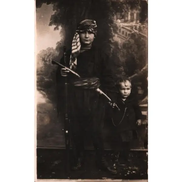 Elinde tüfekle poz veren yöresel kıyafetli çocuk ile kardeşinin stüdyo fotoğrafı, 9x14 cm