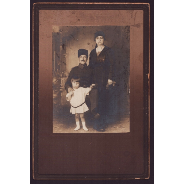 Kalpaklı Türk subayının eşi ve minik kızıyla birlikte aldırdığı stüdyo kabin fotoğrafı, ithaflı ve imzalı, paspartusuyla birlikte 16x23 cm...