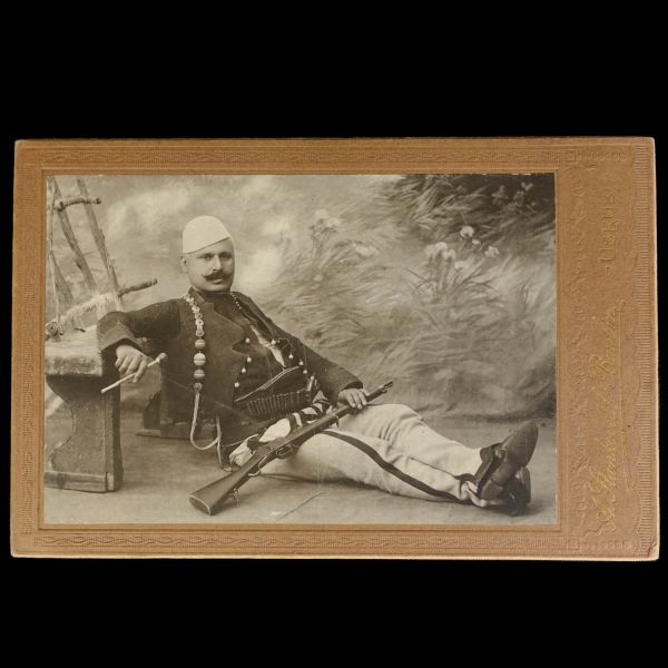 Üsküplü bir Arnavut komitacının, bir elinde tüfeği, bir elinde tütün çubuğu ile poz vererek aldırdığı kabin fotoğraf, Baubin Stankovitch, Uskub, 17x11 cm...