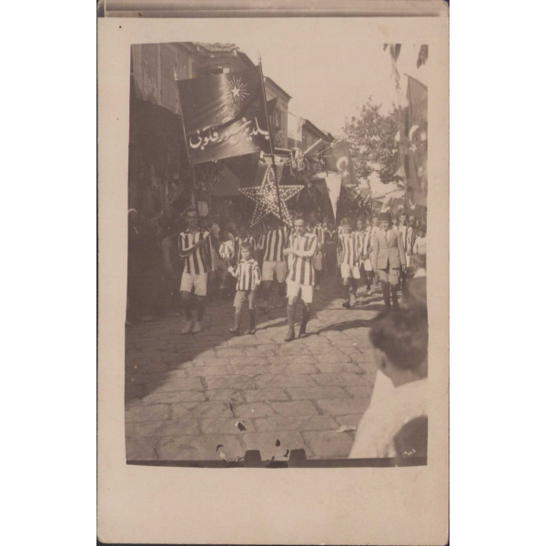 İzmir'in kurtuluş günü hatırası, İzmir İkiçeşmelik Spor Kulubü afişiyle yürüyen futbolcular, 9 Eylül 1341 (1925) tarihli, arkası Osmanlıca yazılı