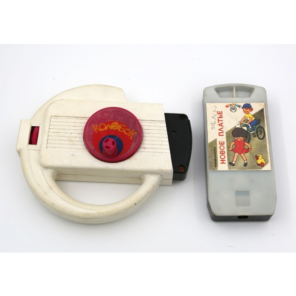 Rus malı plastik manuel çizgi film oynatıcı, iki adet kasediyle birlikte, kasetlerden biri haliyle, 17x14x4 cm